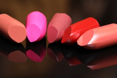 Photo of Many different bright lipsticks on mirror, closeup