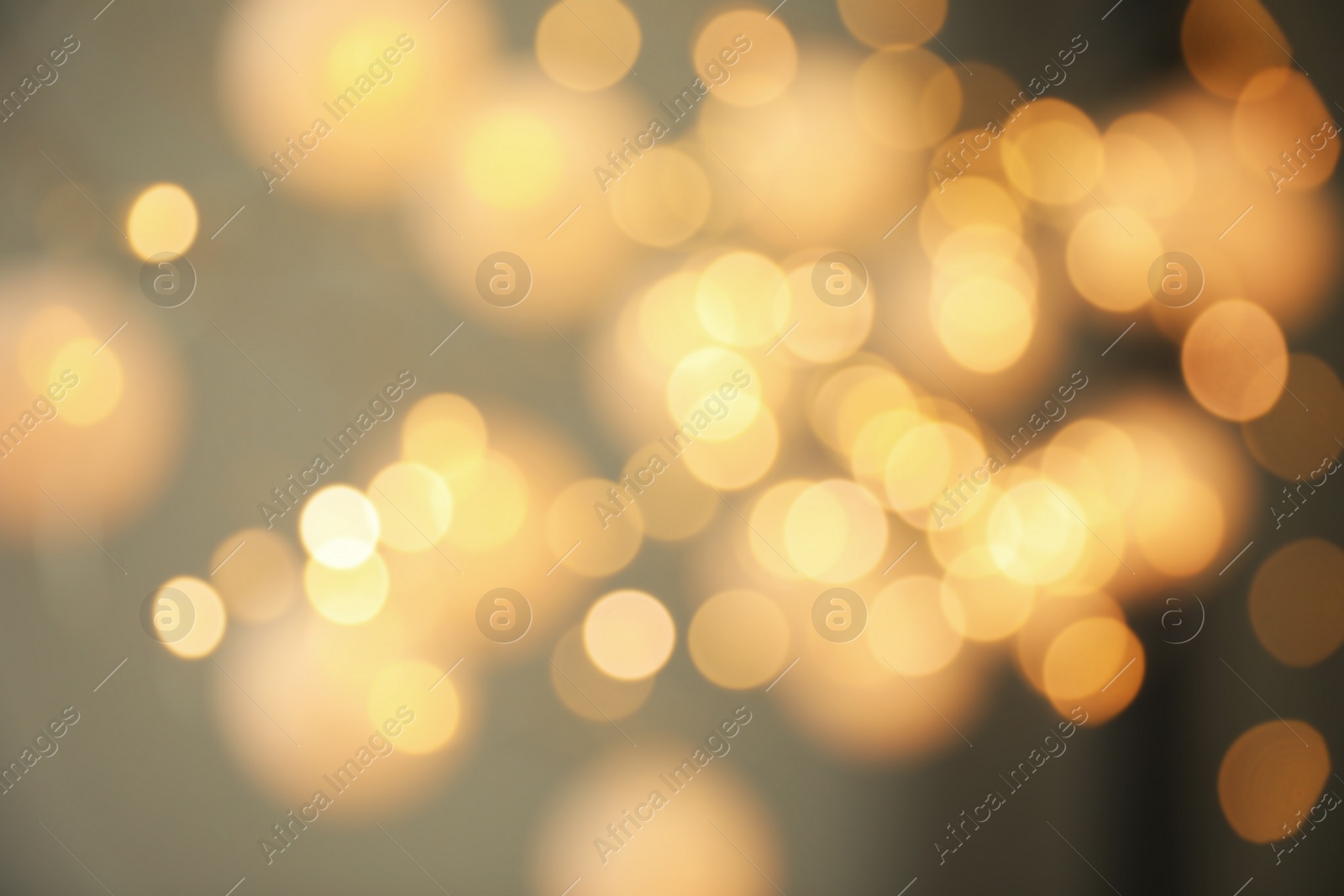 Photo of Blurred view of gold lights on dark background. Bokeh effect