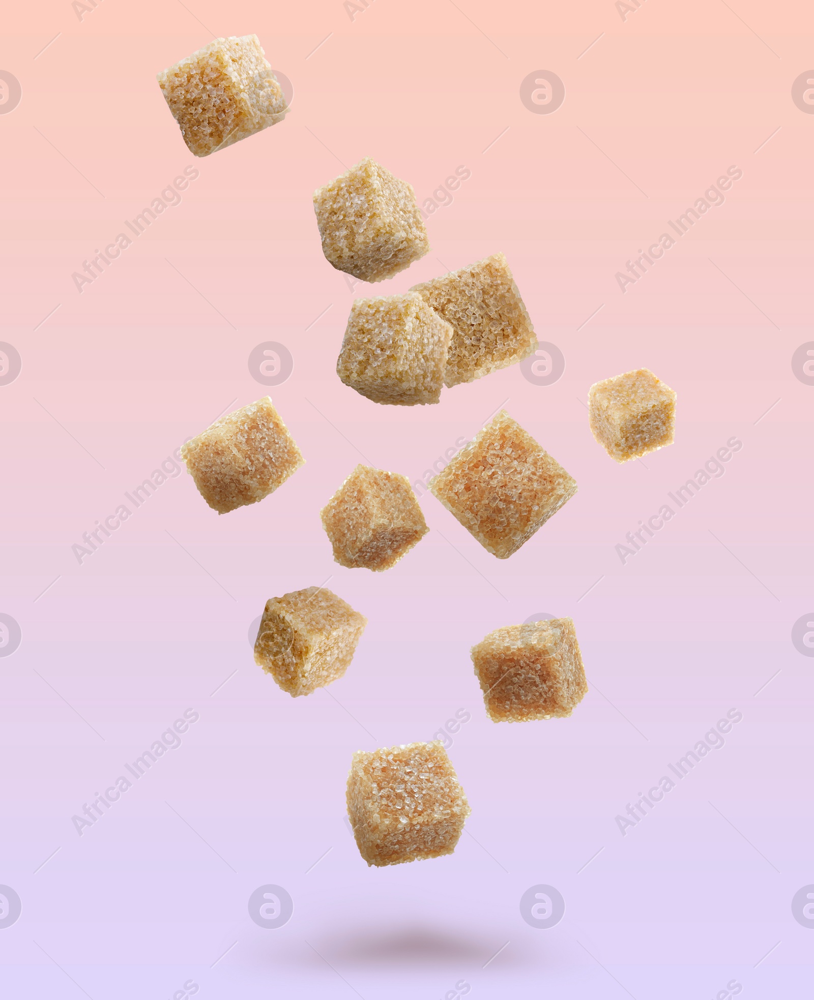 Image of Brown cane sugar cubes falling on color gradient background