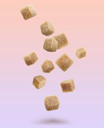 Image of Brown cane sugar cubes falling on color gradient background