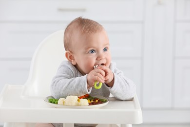 Photo of Cute little baby eating healthy food at home