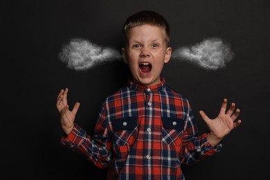 Image of Aggressive little boy with steam coming out of his ears on black background