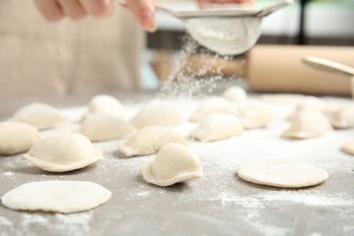 Photo of Woman cooking delicious dumplings at table, closeup