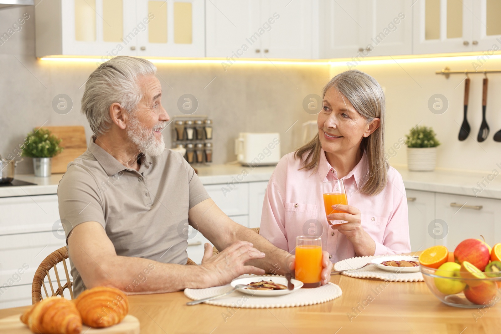 Photo of Happy senior couple having breakfast at home