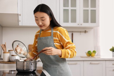 Photo of Beautiful woman cooking in kitchen. Space for text