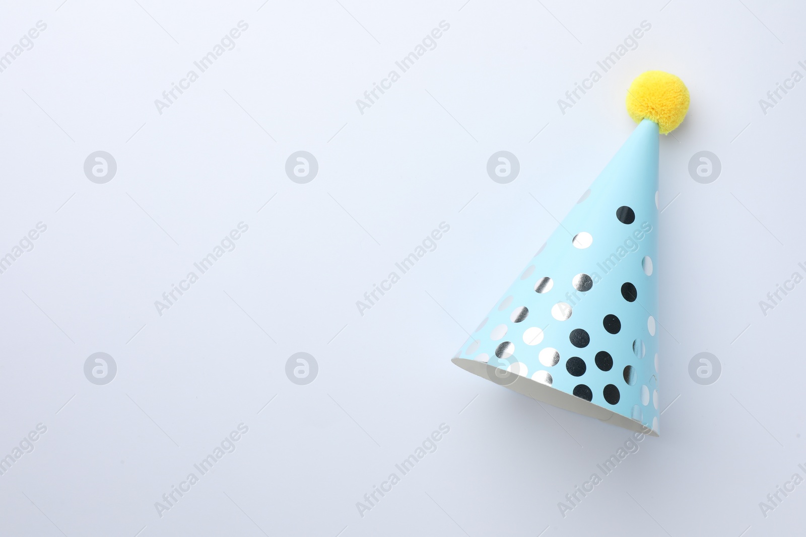 Photo of One blue party hat on light background, top view. Space for text