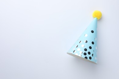 One blue party hat on light background, top view. Space for text