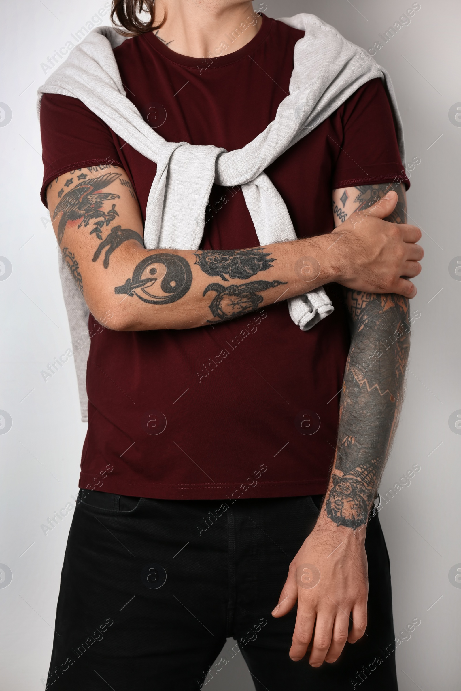 Photo of Young man with stylish tattoos on white background