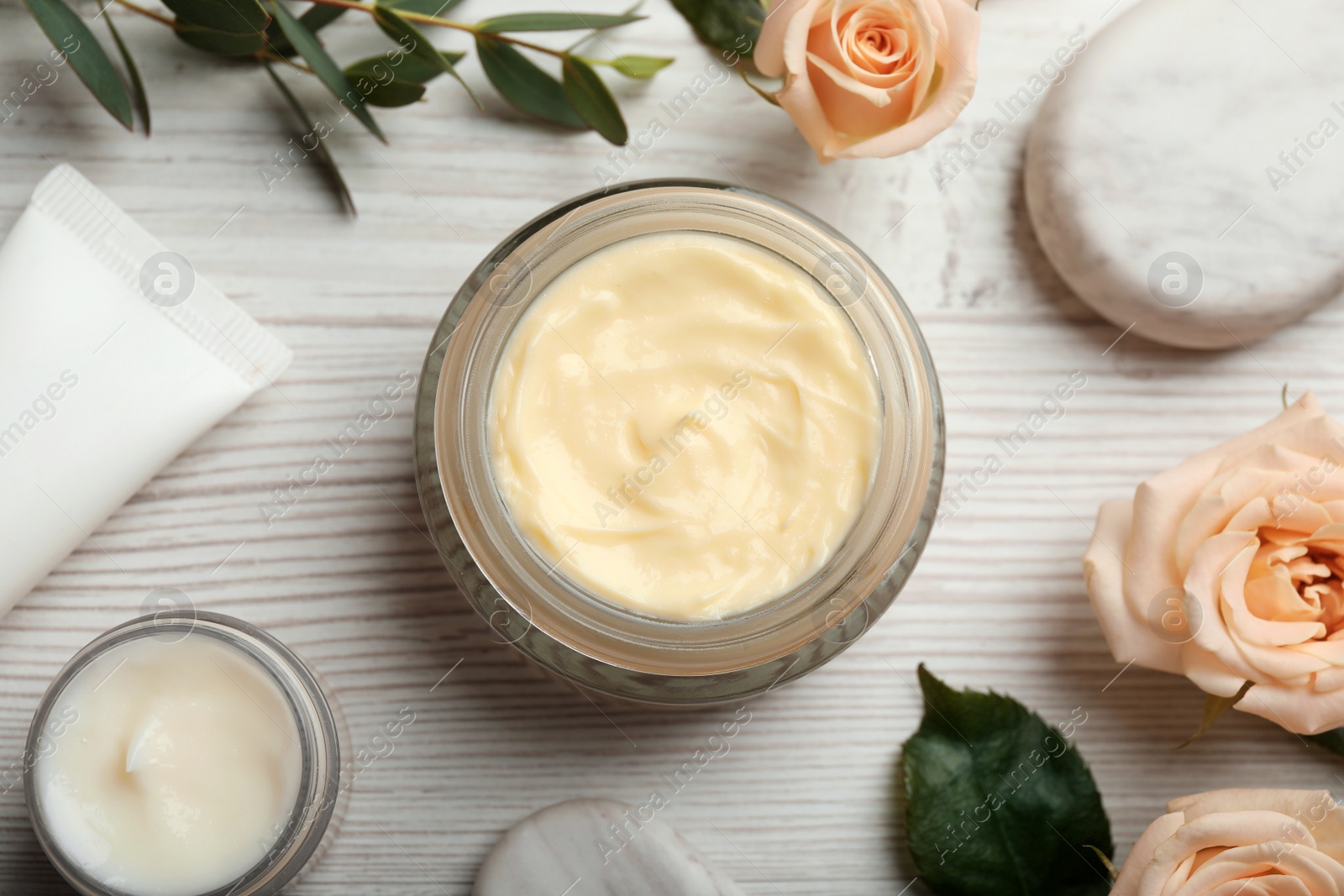 Photo of Flat lay composition with jars of organic cream on white wooden table