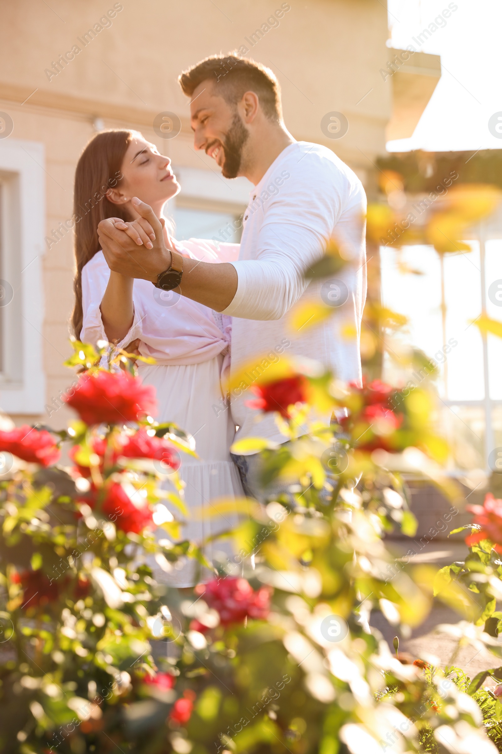 Photo of Lovely young couple dancing together outdoors on sunny day