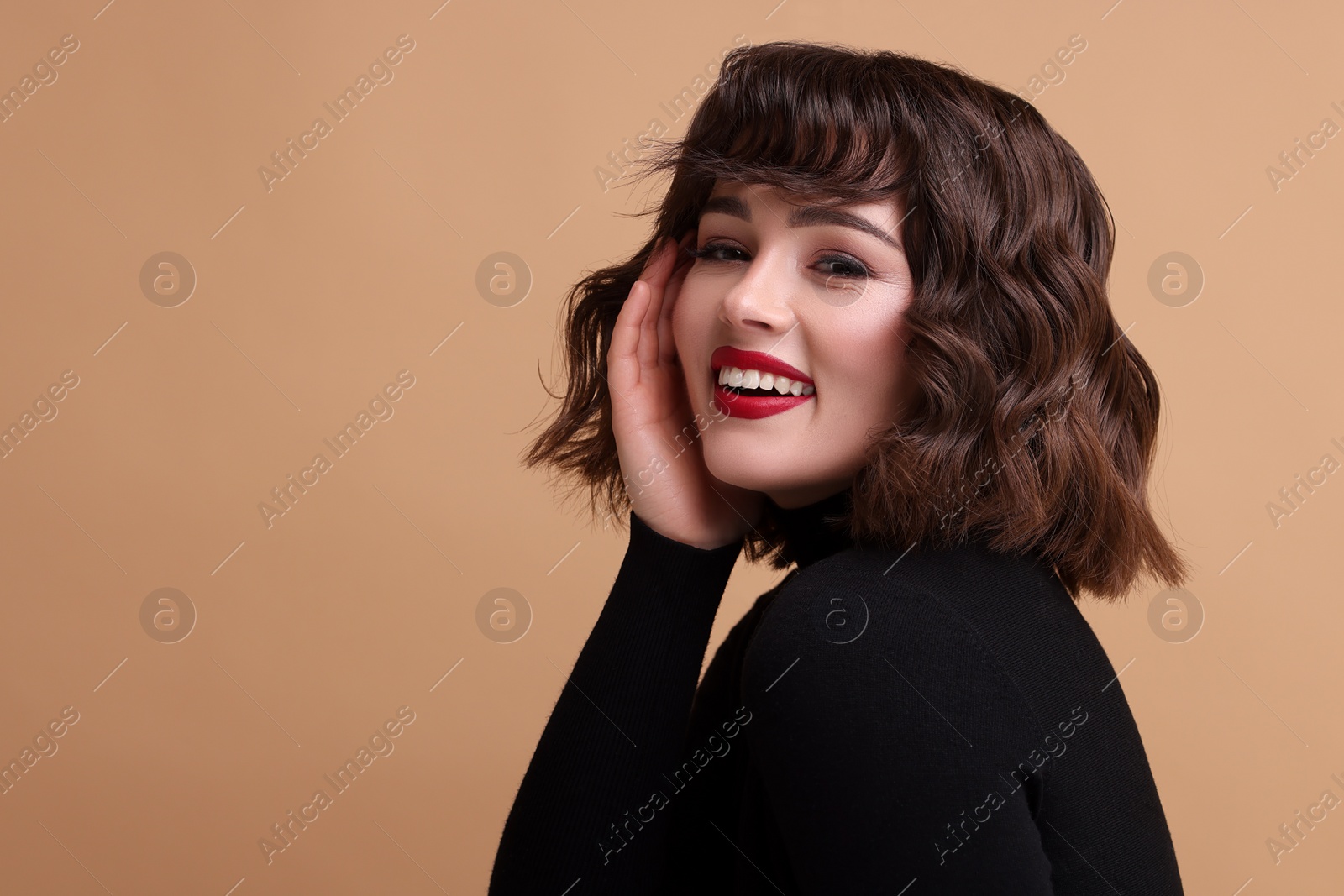 Photo of Portrait of beautiful young woman with wavy hairstyle on beige background. Space for text