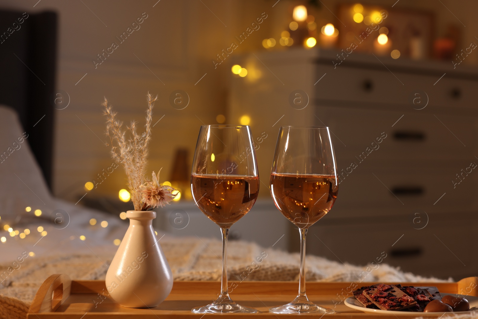 Photo of Tray with glasses of wine on bed. Romantic evening