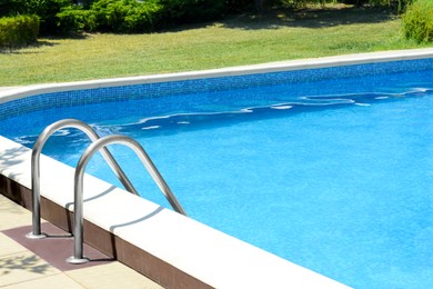 Photo of Swimming pool with metal ladder on sunny day