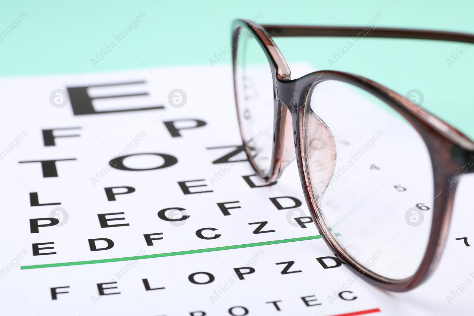 Photo of Vision test chart and glasses on table, closeup