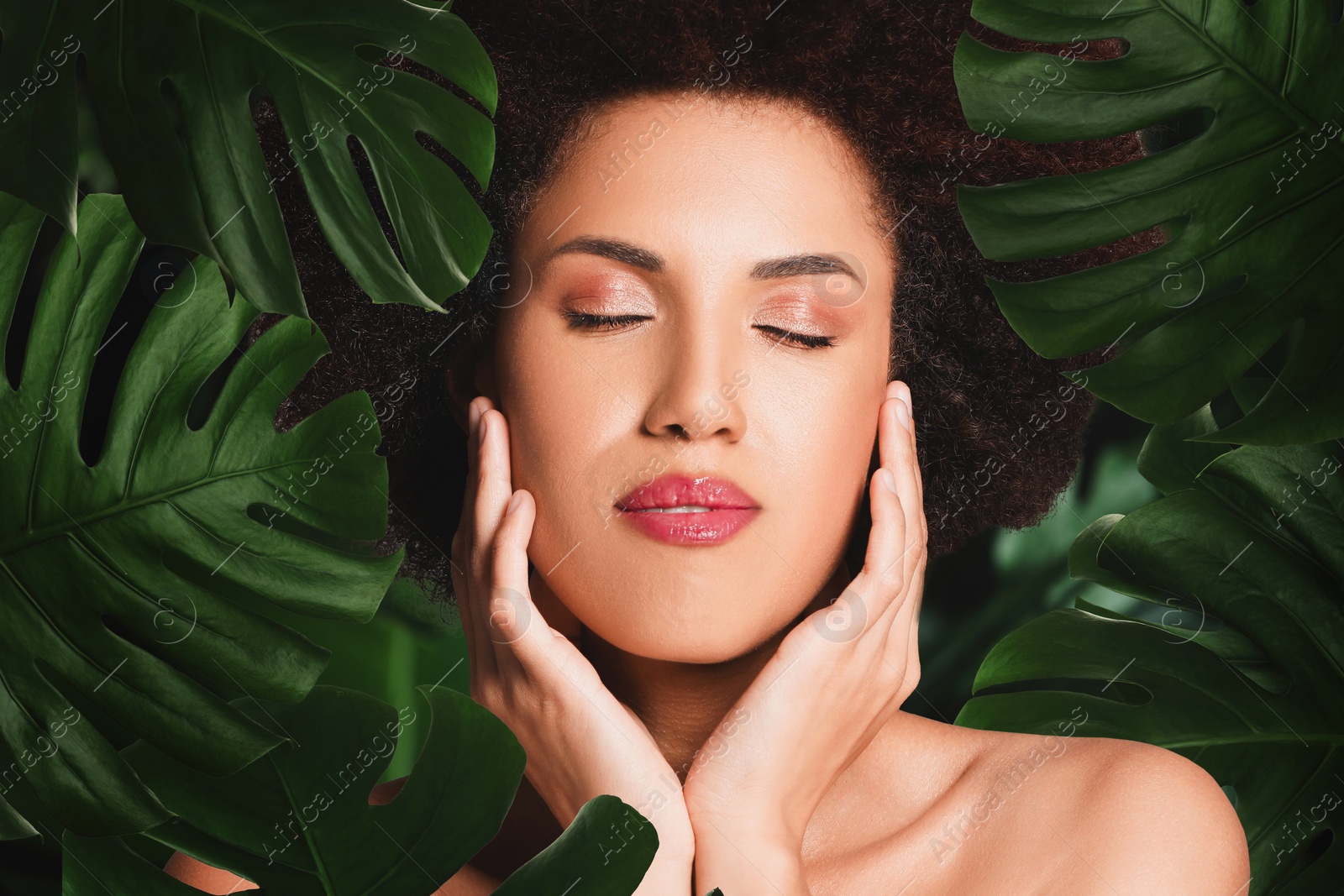 Image of Beautiful young woman surrounded by green leaves feeling harmony while enjoying nature