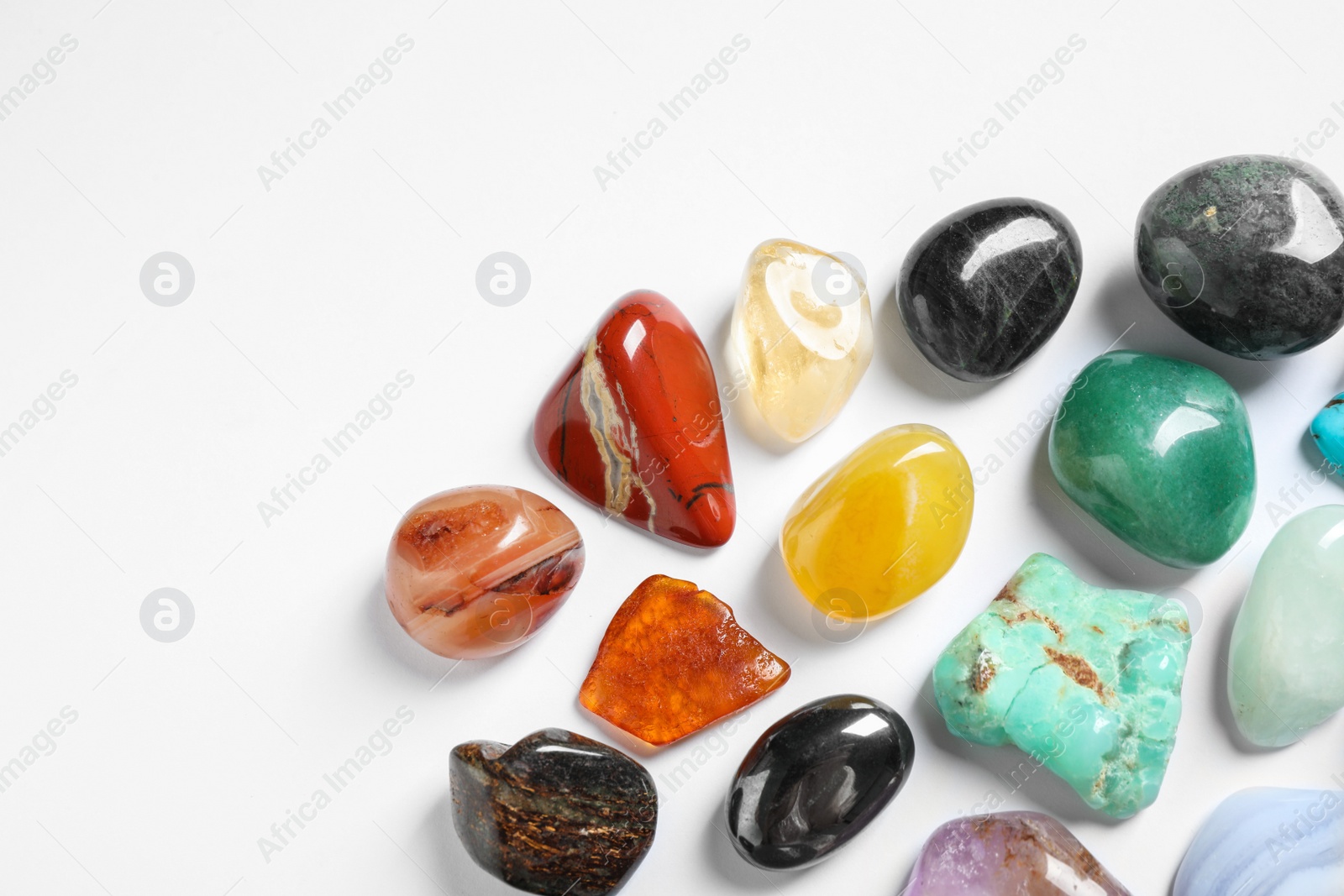 Photo of Different beautiful gemstones on white background, top view