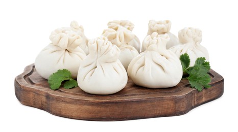 Photo of Wooden board with uncooked khinkali (dumplings) and parsley isolated on white. Georgian cuisine