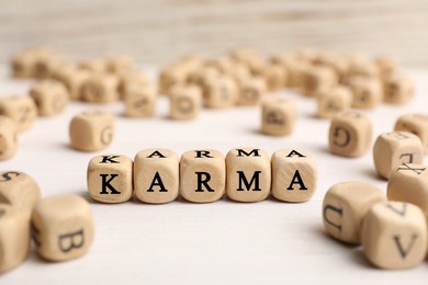 Photo of Word Karma made of cubes with letters on white table