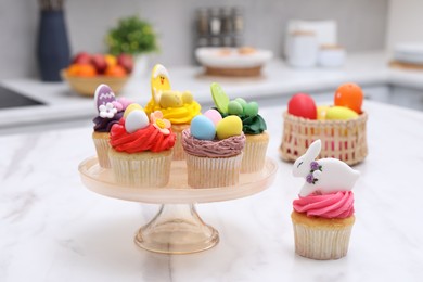 Tasty cupcakes with Easter decor on white marble table