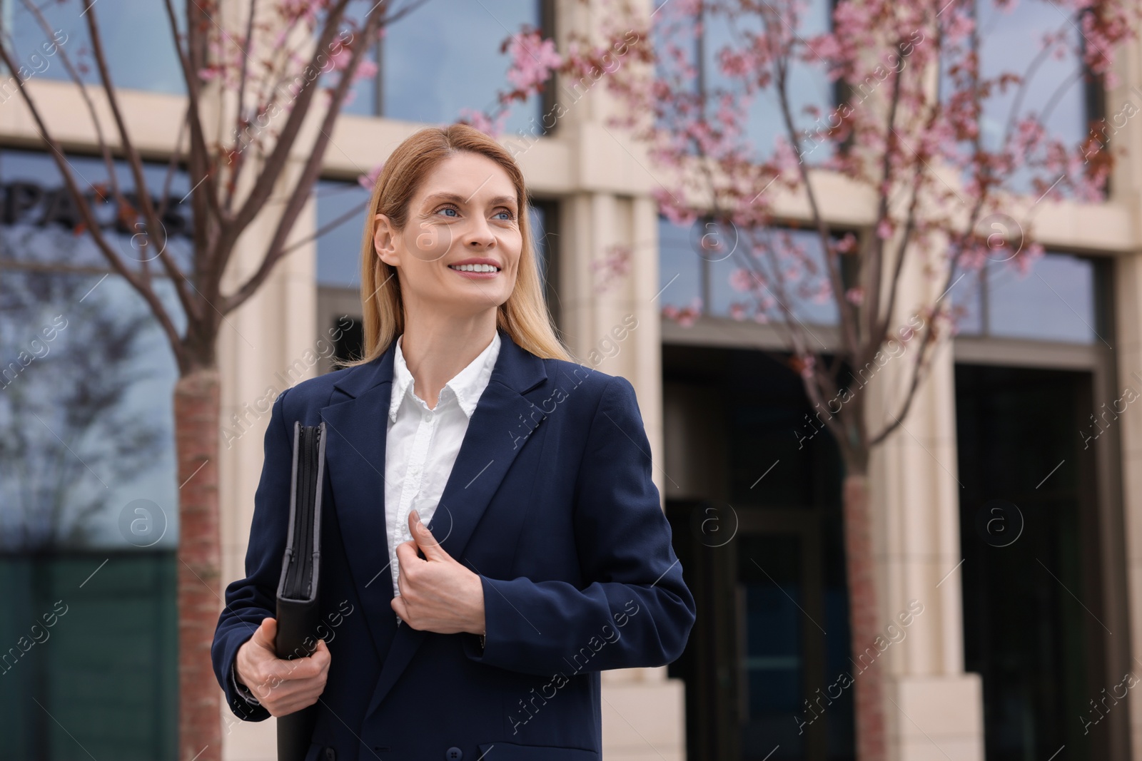 Photo of Real estate agent with leather portfolio outdoors. Space for text