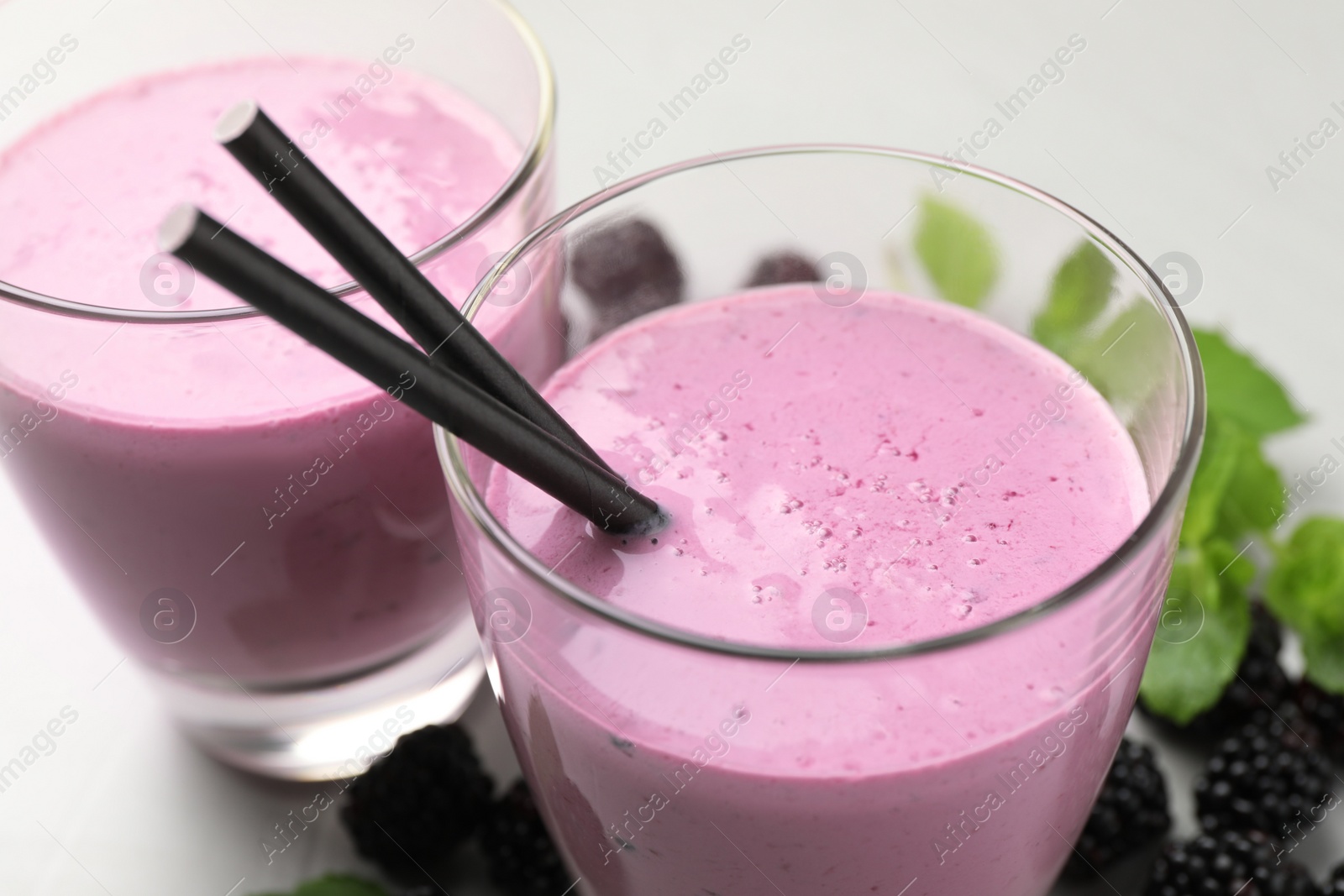 Photo of Delicious fresh blackberry smoothie in glasses, closeup