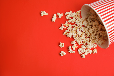 Tasty pop corn on red background, flat lay. Space for text