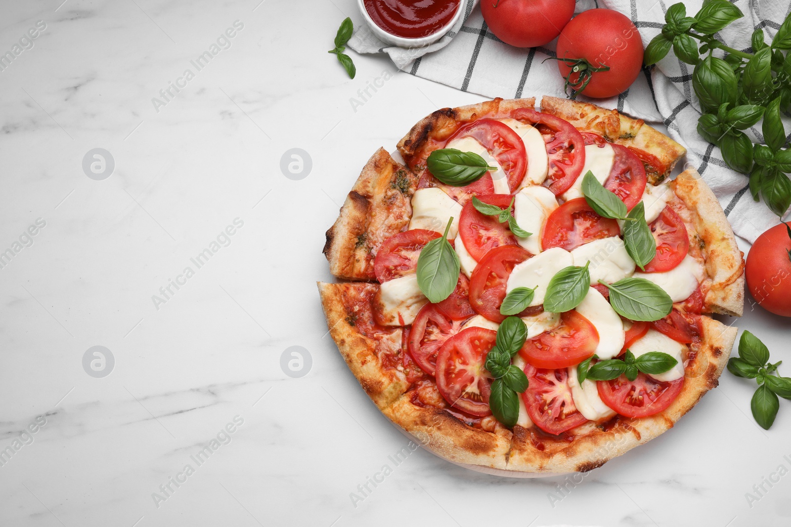 Photo of Delicious Caprese pizza with tomatoes, mozzarella and basil served on white marble table, flat lay. Space for text