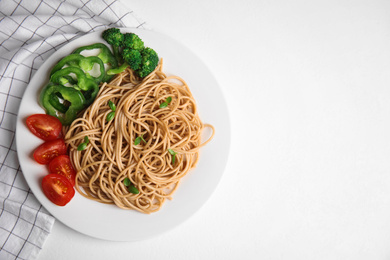 Photo of Tasty buckwheat noodles with fresh vegetables served on white table, flat lay