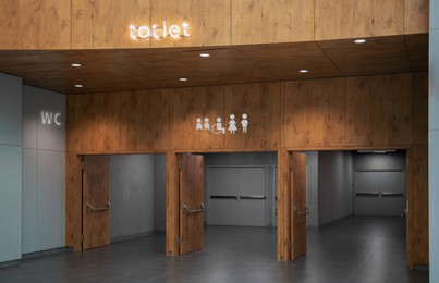 Image of Public toilet signs on wooden wall over entrance