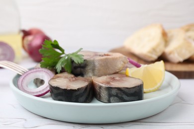 Photo of Slices of tasty salted mackerel with parsley, onion ring and lemon wedge on light table, closeup