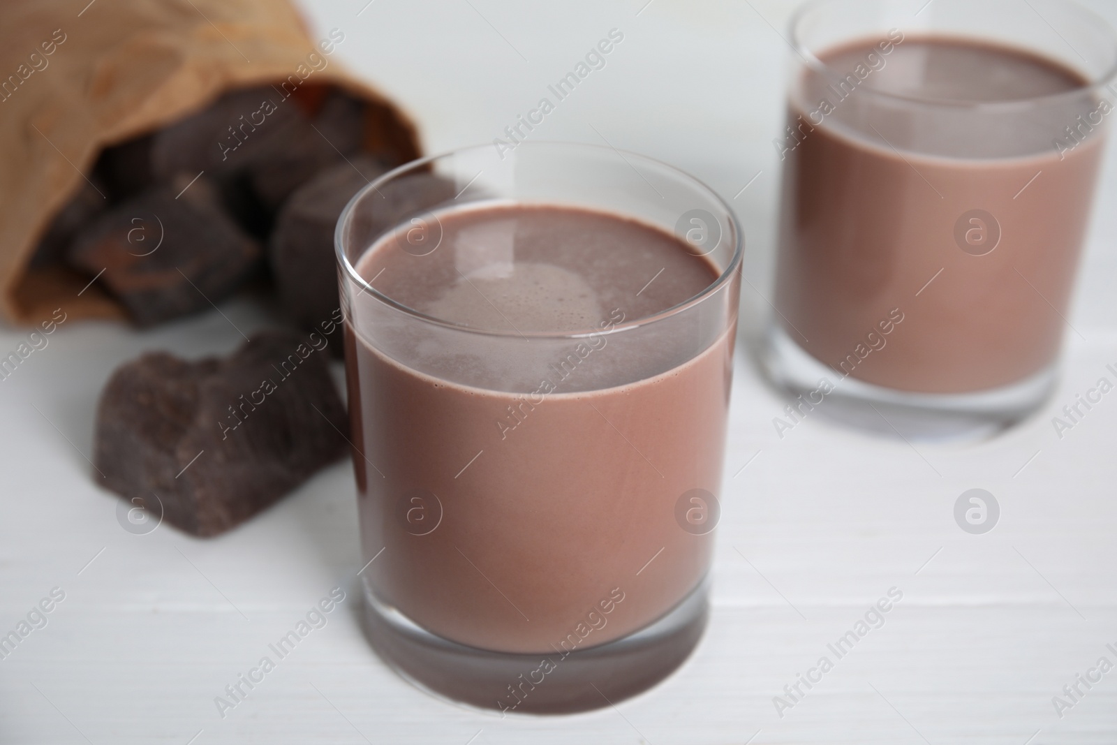 Photo of Delicious chocolate milk on white wooden table