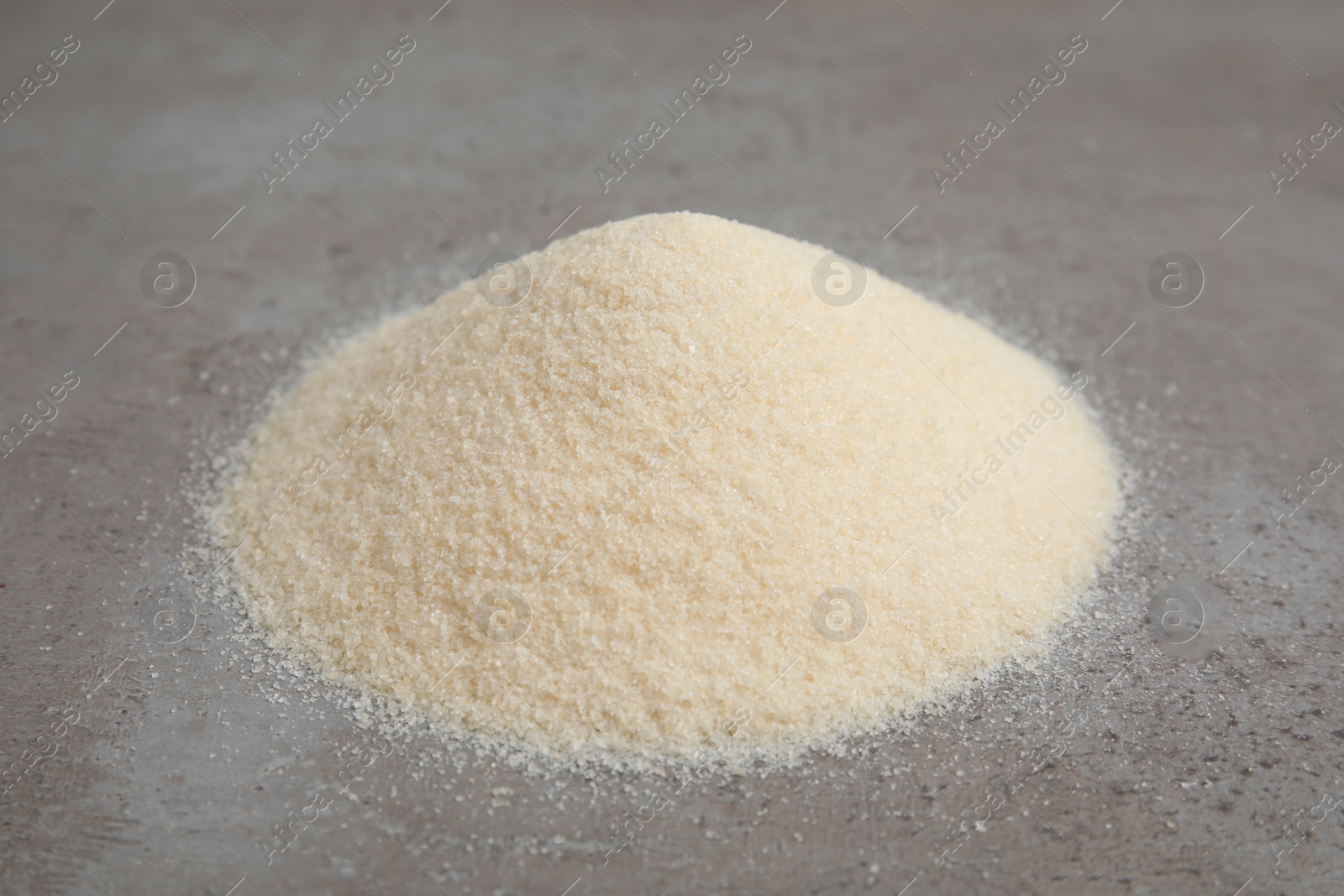 Photo of Pile of gelatin powder on grey table