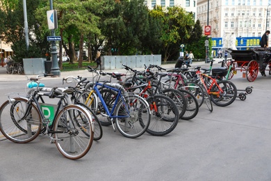 Photo of VIENNA, AUSTRIA - APRIL 26, 2019: Different bicycles parked near road on sidewalk