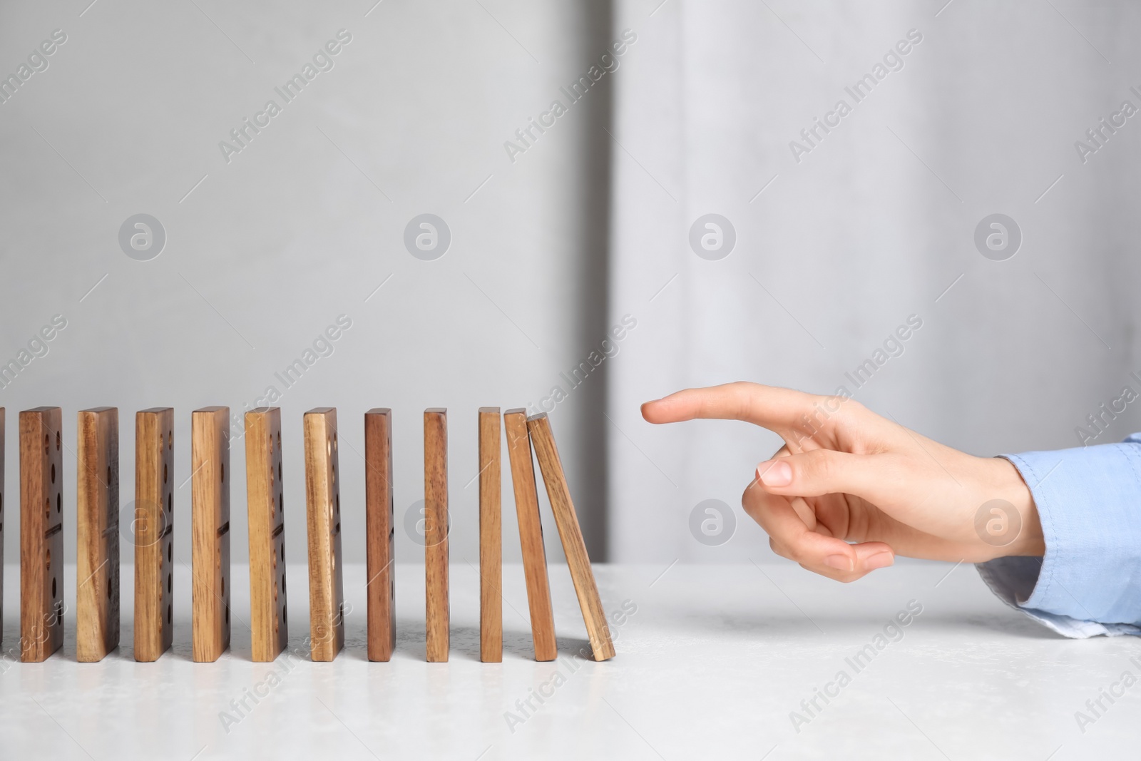 Photo of Woman with wooden dominoes at white table, closeup