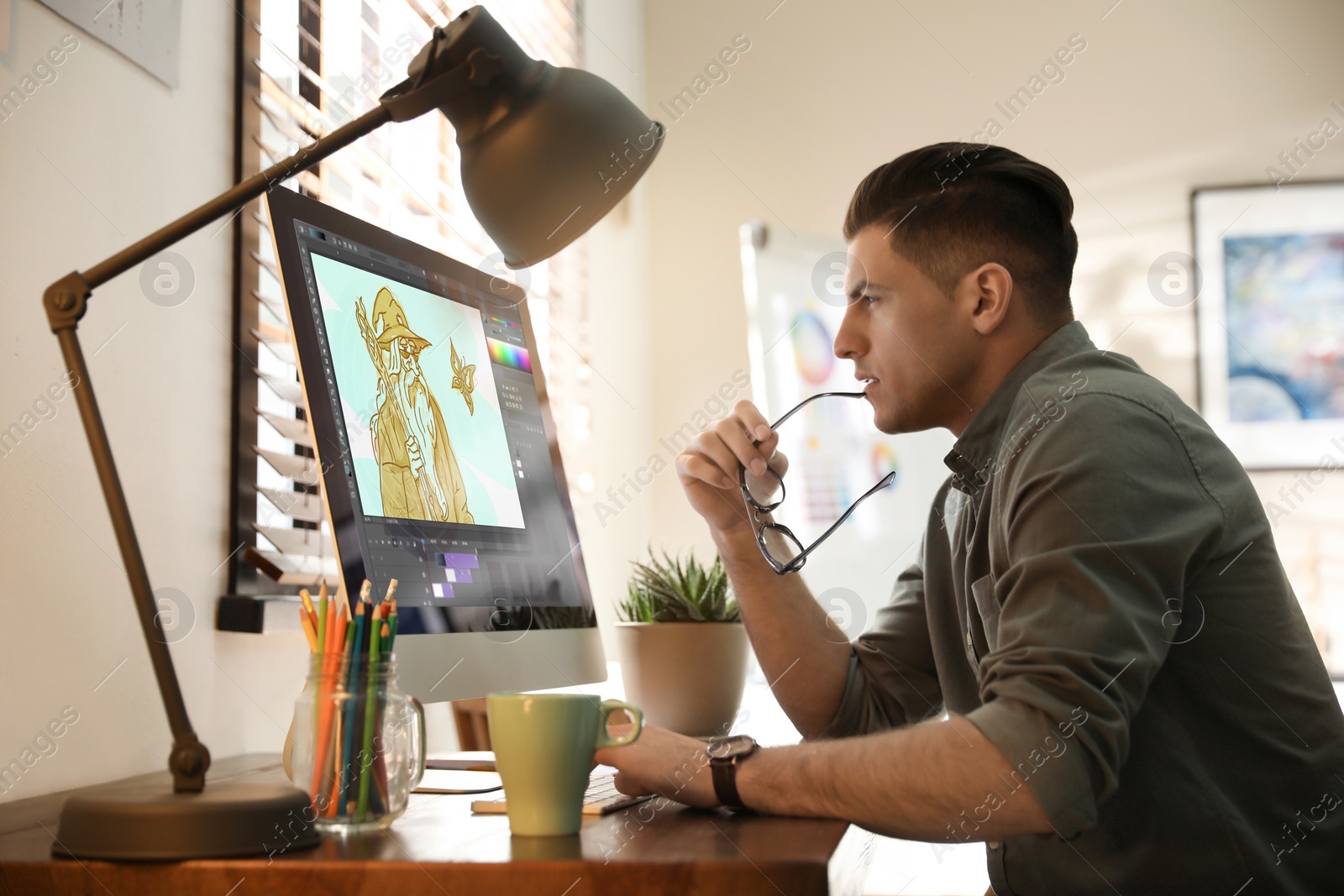 Image of Animator working at table. Modern computer with illustration on screen