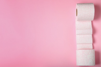 Photo of Rolls of toilet paper on color background, top view. Space for text