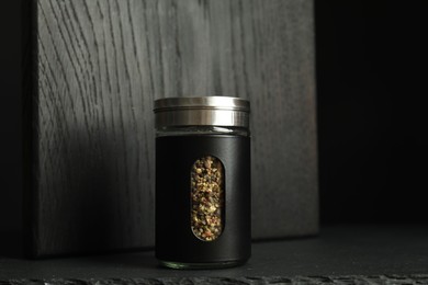 One stylish pepper shaker on black table