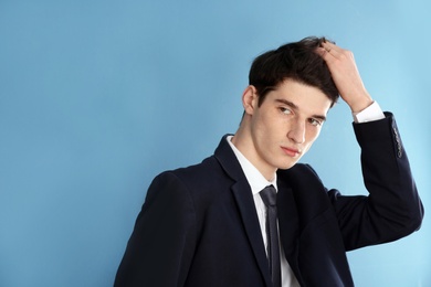 Portrait of young businessman with beautiful hair on color background