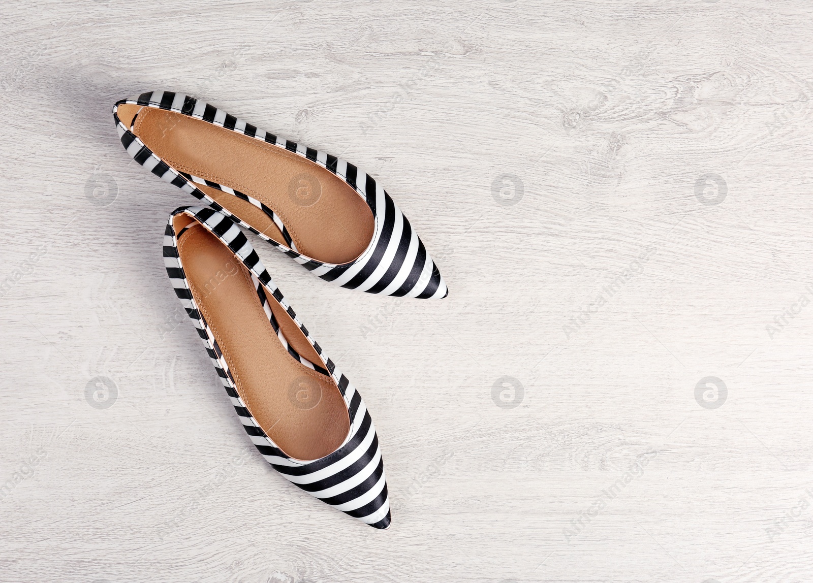 Photo of Pair of female shoes on wooden background, top view