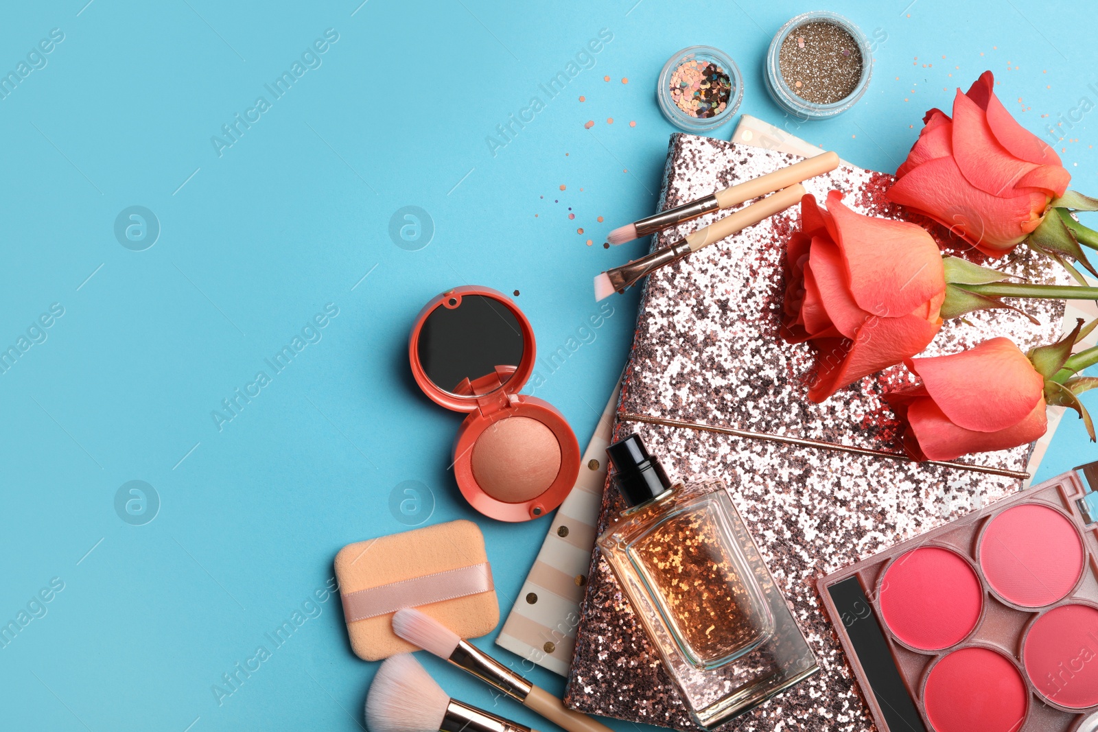 Photo of Flat lay composition with coral cosmetics and flowers on light blue background. Space for text