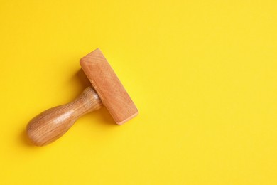 One wooden stamp tool on yellow background, top view. Space for text