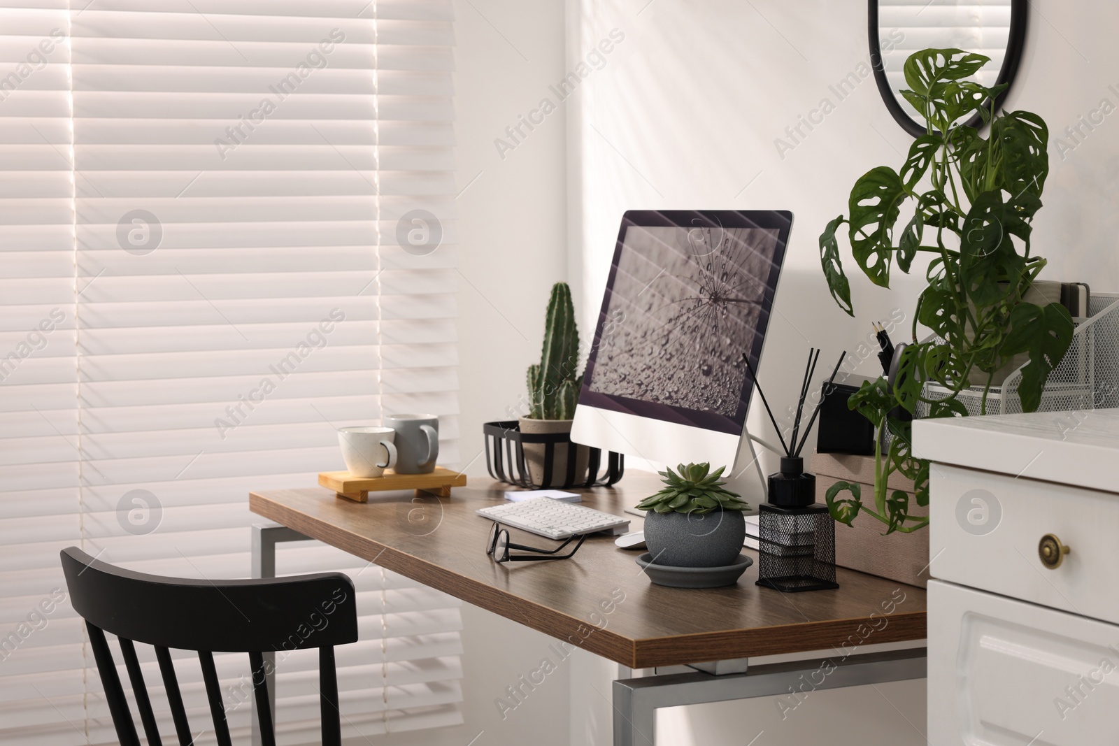 Photo of Cozy workspace with computer on wooden desk at home