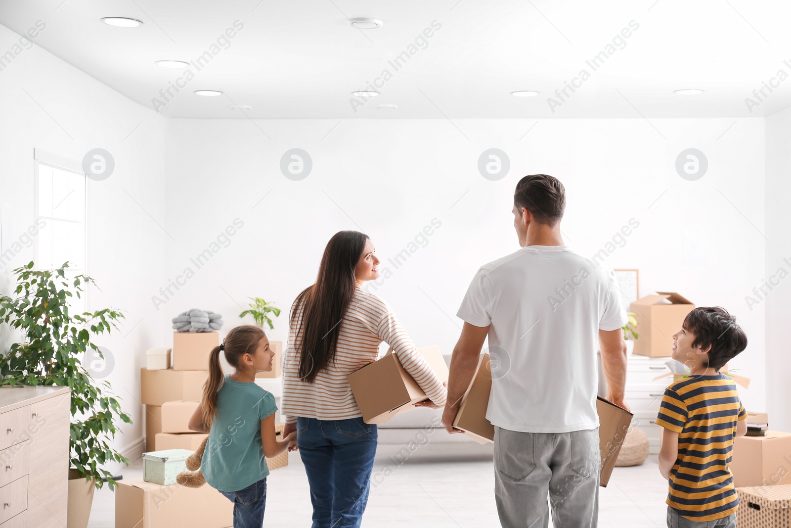 Photo of Family in room with cardboard boxes on moving day