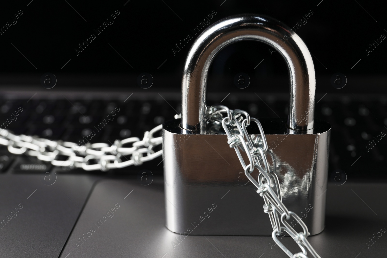 Photo of Cyber security. Padlock with chain on laptop, closeup