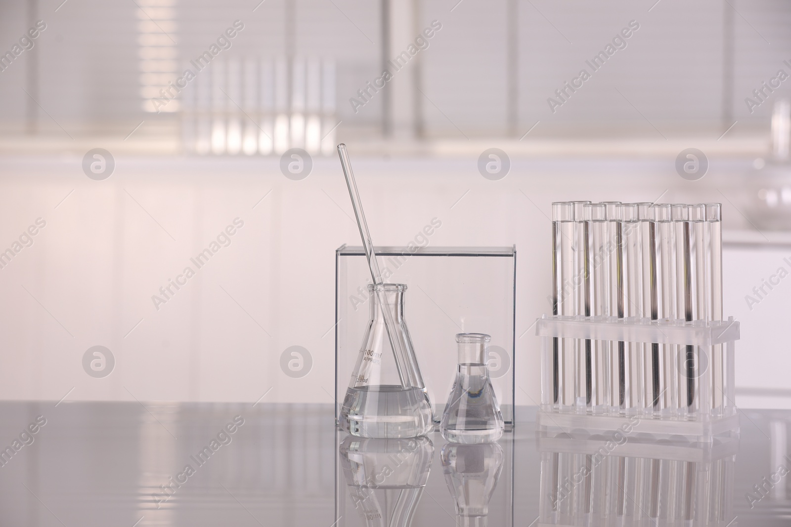 Photo of Laboratory analysis. Different glassware with liquid on white table indoors, space for text