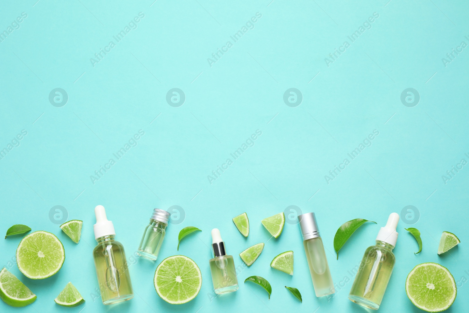 Photo of Flat lay composition with lime essential oil on light turquoise background. Space for text