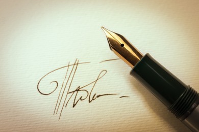 Image of Sheet of paper with fountain pen and signature, top view