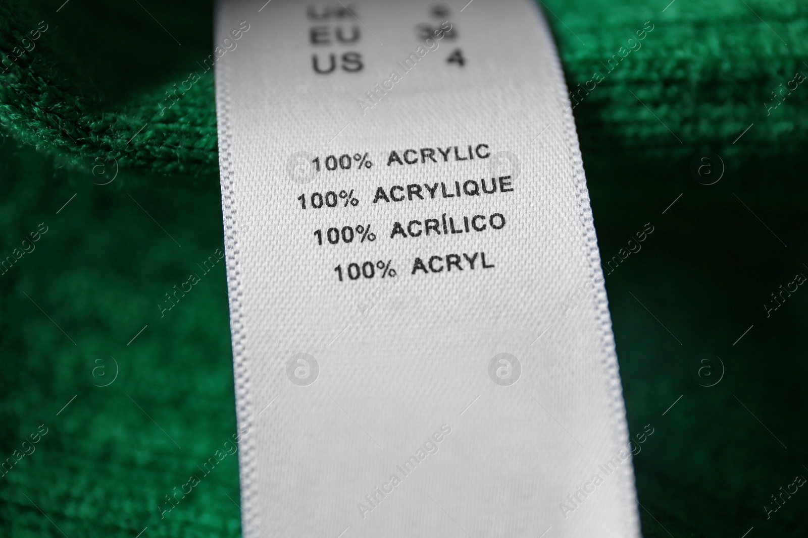 Photo of Clothing label with material content on green shirt, closeup view