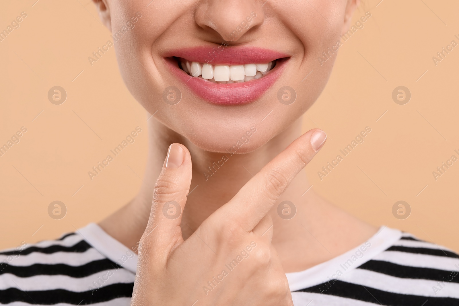 Photo of Woman with clean teeth smiling on beige background, closeup