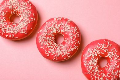 Photo of Delicious glazed doughnuts on color background, top view